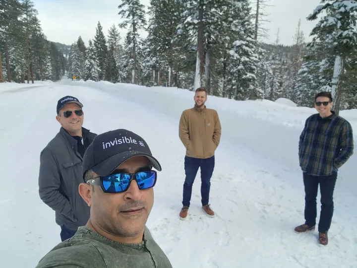 Four members of the Invisible AI team standing outside in the snow